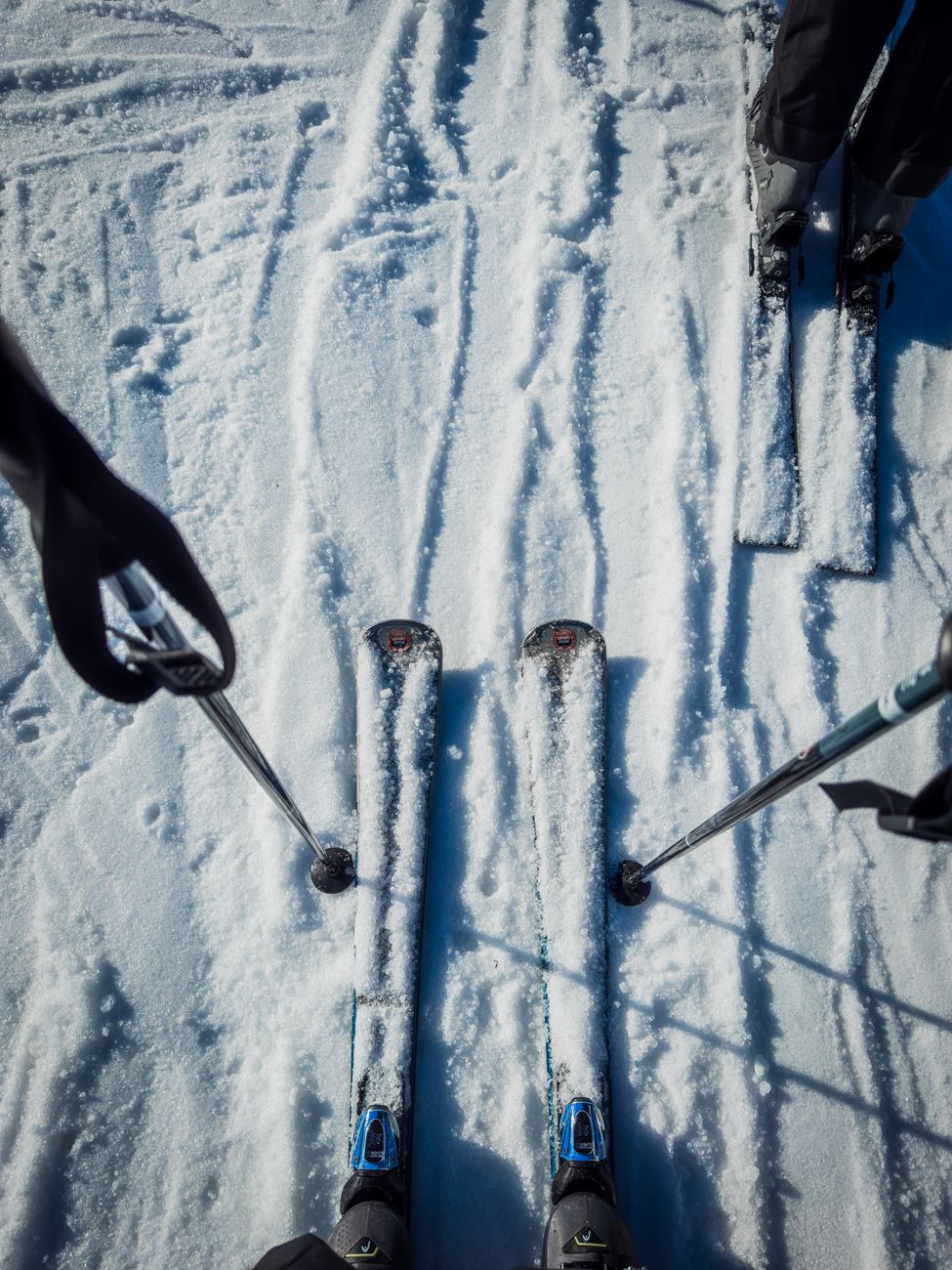 skis on snowy slope with poles in winter